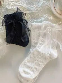 Dos pares de calcetas uno negro y uno blanco con detalle de moño organza